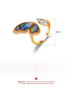 Macro detail of copper butterfly ring with abalone shell inlay and zircon accents
