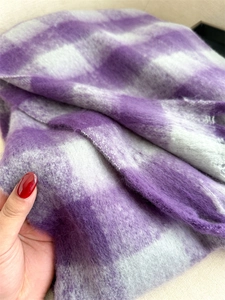 Detailed macro view showing purple and white checkered plaid cashmere-like fabric texture