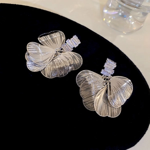 Détail de boucles d'oreilles feuilles d'argent et cristaux de zircon sur velours noir