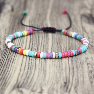 Detail of bohemian woven bracelet with colorful beads and golden metal spacers