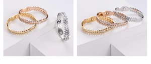 Detailed view of wave textured bracelets in gold, rose gold and silver with zircon inlay