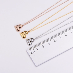 Vue détaillée de petits pendentifs en cœur avec cristaux sur une règle de mesure