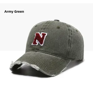 Detailed view of army green baseball cap with embroidered N logo and frayed vintage brim