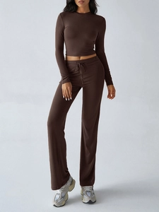 Detail of a brown long-sleeved cropped top and matching drawstring pants for women