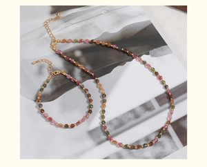 Close-up of mixed colorful tourmaline stone beaded necklace and bracelet set with gold clasp