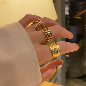 Three-piece set of golden stainless steel rings including curb chain and hammered texture