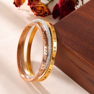Three-tone titanium steel bangles with Roman numerals and crystals on jewelry box