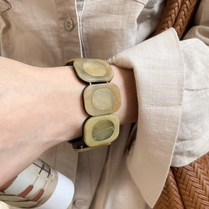 Detailed close-up of resin cuff bracelet featuring amber and olive green marbled textures