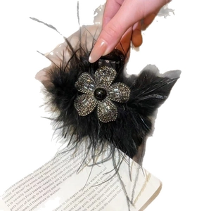 Elegant black feather hair claw clip with silver rhinestone flower and black bead center