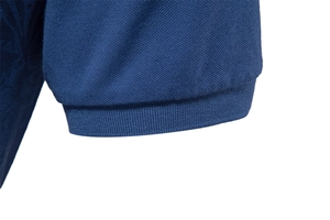 Detailed close-up of blue polo shirt sleeve cuff with 1x1 rib knit and piqué fabric