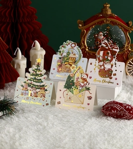 Set of four gold-stamped Christmas cards with festive tree and reindeer illustrations