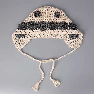 Close-up of handmade crochet bandana with floral pattern and decorative tassel ties