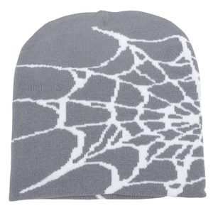 Detailed close-up of white spider web jacquard pattern on a grey knit beanie hat