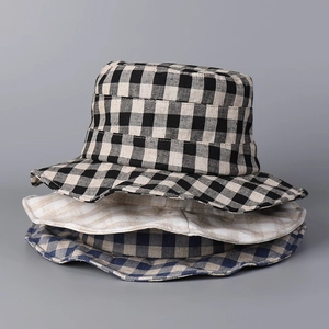 Close-up of stacked linen checkered bucket hats in black, beige, and blue patterns