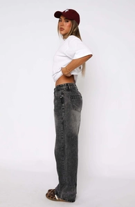 Side view of women's black washed denim jeans showing loose straight cut and fabric texture