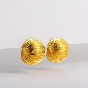 Detailed view of 18K gold shell earrings with radial textures and high polished finish