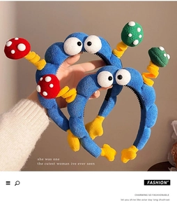 Detail of blue plush headband with cartoon eyes and colorful spring mushroom accents