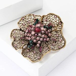 Detail of vintage flower brooch featuring colorful rhinestones on antique gold metal petals