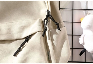 Detail view of durable canvas backpack with woven zipper pulls and brand textile label