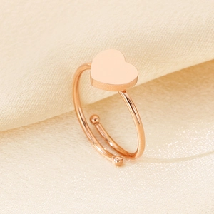 Detailaufnahme des roségoldenen Edelstahlrings mit Herzform auf Seidenstoff