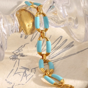 Detailed close-up of 18K gold plated chain with sky blue enamel ring clasp closure