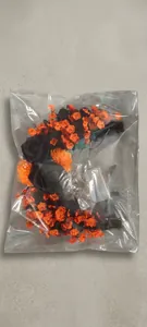 Close-up of Halloween moon cat wreath with black roses and orange flowers in packaging