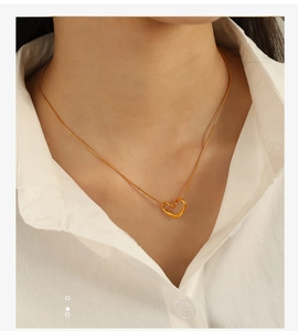 Gros plan du pendentif cœur minimaliste plaqué or 18 carats sur une fine chaîne serpent