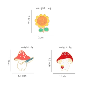 Three-piece cartoon enamel pin set featuring sunflower and mushroom characters with measurements