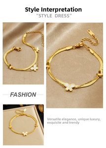 Detail of double-layer gold snake chain bracelet with white butterfly charms on silk background