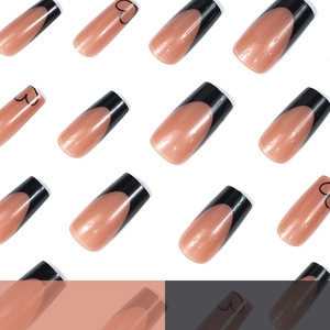Classic French nude press-on nails with black tips and heart designs in long coffin shape