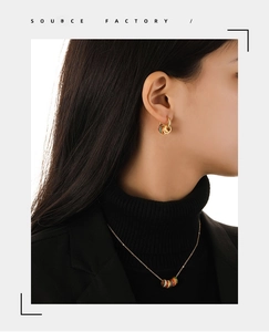 Detail of colorful enamel hoop earrings and matching necklace set on female model