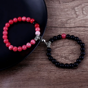 Close-up of magnetic heart beads couple bracelet in red and black natural stones