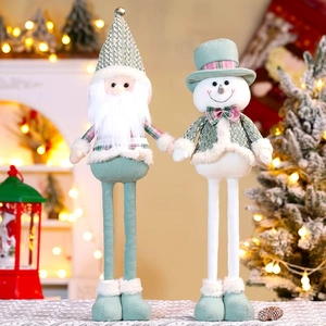 Close-up of mint green plush Santa and snowman dolls with plaid accents and bells