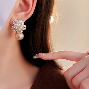 Detailansicht eleganter Blumenstecker mit Kristallen und Champagnerperle am Modell getragen