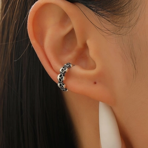 Detailed view of vintage silver skull ear cuff on ear lobe for Halloween look