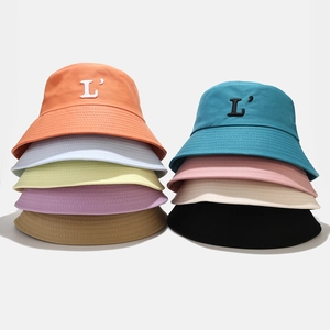 Plusieurs coloris de bobs en toile avec broderie lettre L présentés en empilement