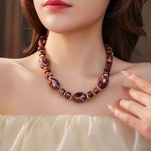 Vintage tortoiseshell resin beaded necklace with gold spacers on female model neck