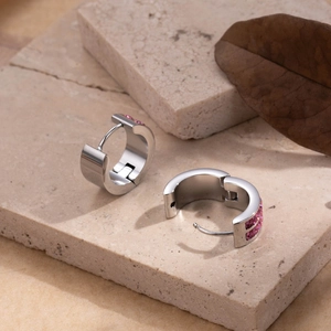 Dual-row pink zircon stainless steel huggie earrings on minimalist stone surface