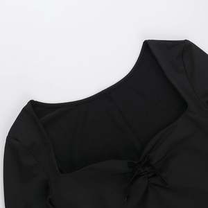 Detail of elegant black square neckline with bow decoration on long sleeve dress