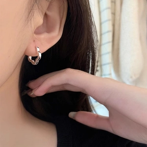 Minimalist s925 sterling silver hollow flower hoop earrings worn by a model in natural light