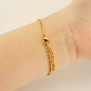 Dettaglio della chiusura a moschettone e catena di estensione del bracciale dorato