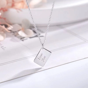 Detailed macro view of silver envelope pendant engraved with Love You on chain