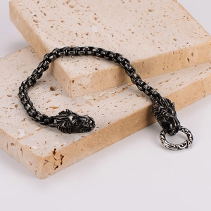 Rugged men's lion head bracelet in antique silver finish on natural stone background