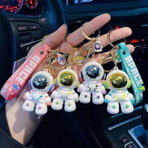 Nahaufnahme bunter Astronauten-Schlüsselanhänger mit SPACE-Gummiband im Auto