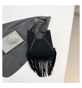 Close-up of bohemian black suede tote featuring sun embroidery, rivets and long fringes