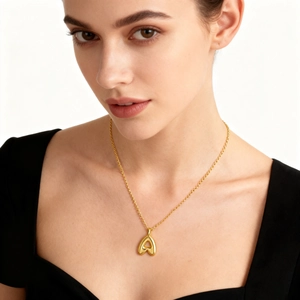 Collier avec pendentif lettre A dorée bombée polie sur une chaîne croisée élégante