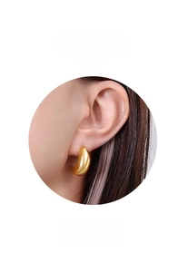 Macro detail of teardrop 18k gold plated earring with minimalist polished finish