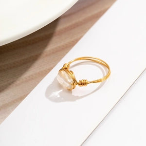 Detail of handcrafted gold wire wrapped ring featuring an irregular white crystal gemstone