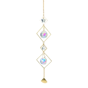 Macro detail of golden metal suncatcher with star crystal prisms and bell pendant charm