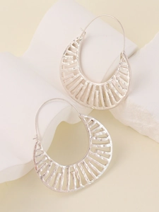 Close-up of silver crescent earrings with hollow striped pattern and metallic texture